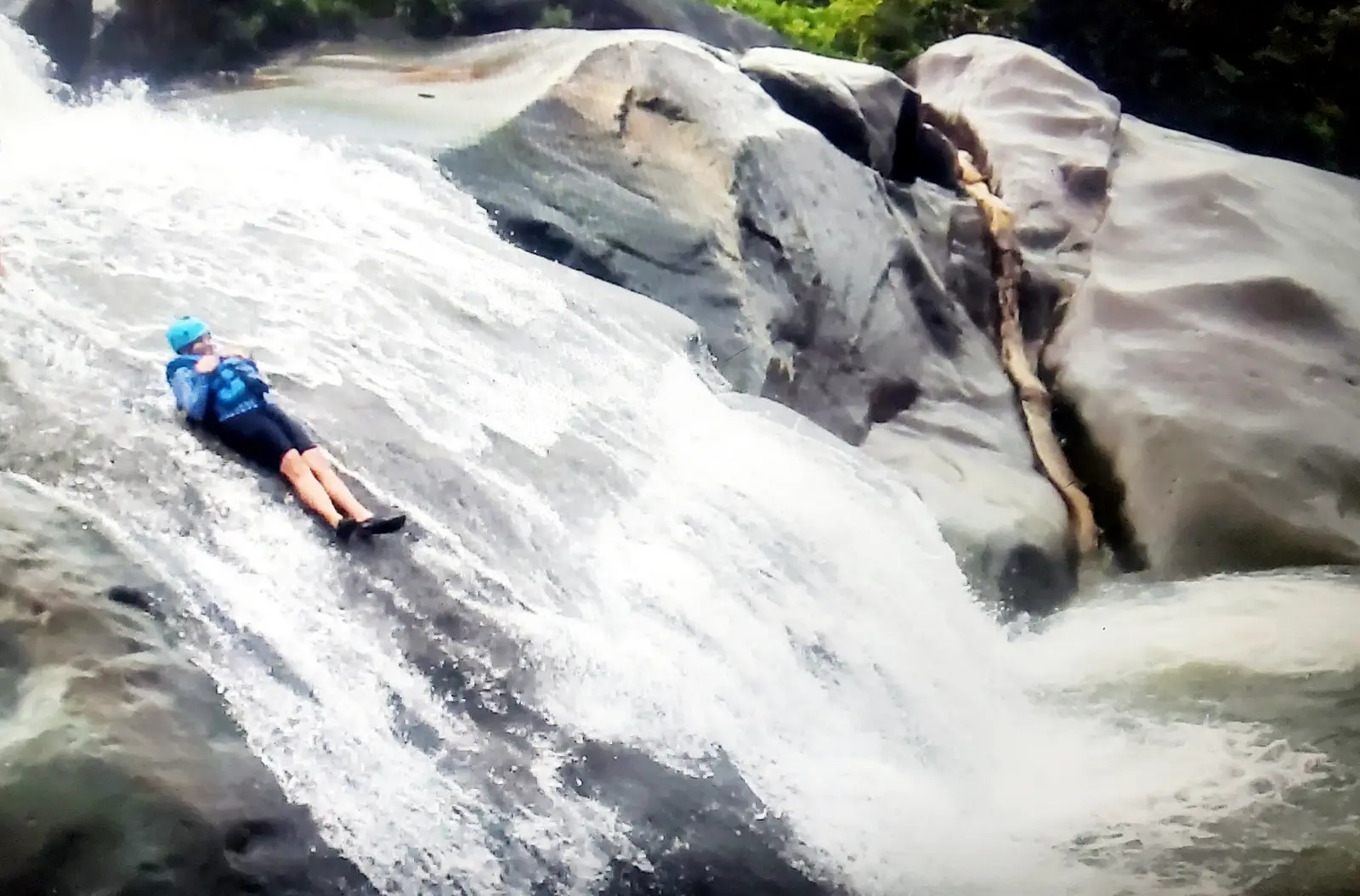 Sliding down the waterfall on the Rio Blanco River.