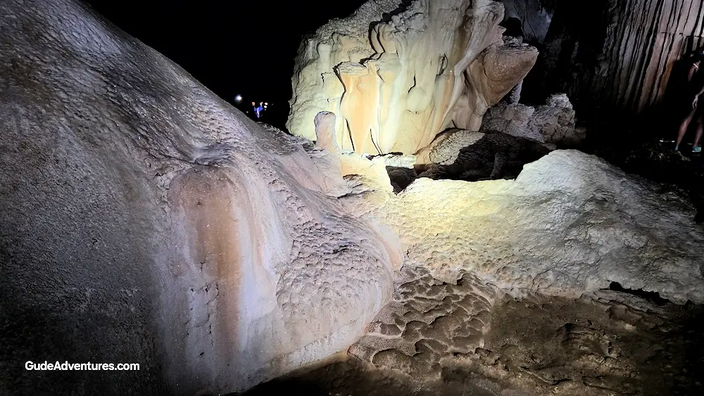 Light reflects off the stalagmite giving the appearance of glass crystals in it.