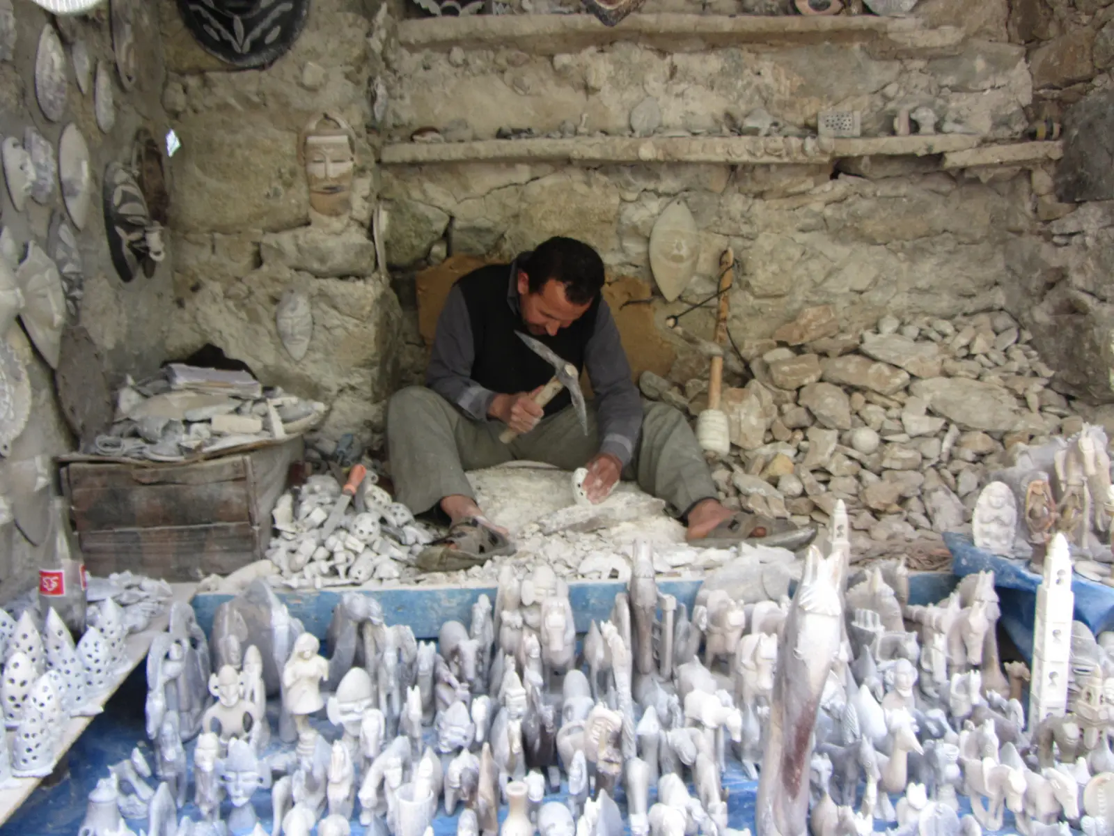 A local artisan carving figurines out of rock.